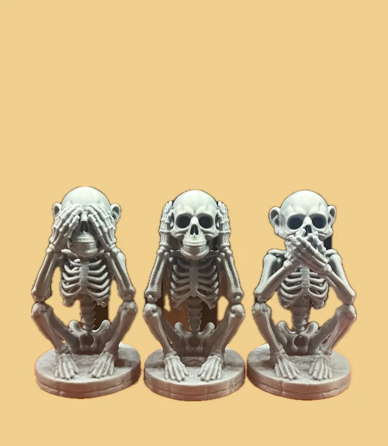Grey trio of seated skeletons covering their eyes, ears and mouth